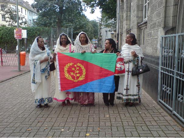 Eriträische Flagge und eine der 9 Nationaltrachten.  